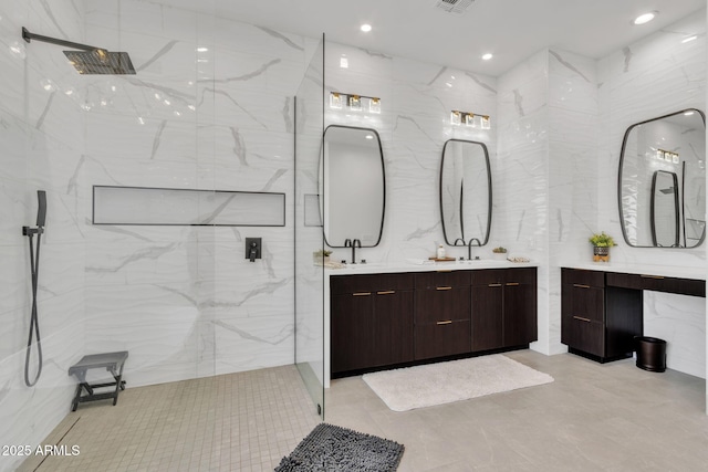 bathroom featuring a sink, double vanity, a marble finish shower, and recessed lighting