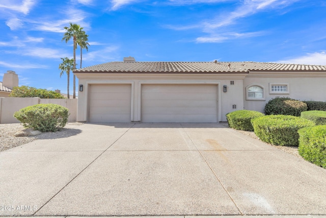 view of front of house featuring concrete driveway, an attached garage, a tile roof, and stucco siding