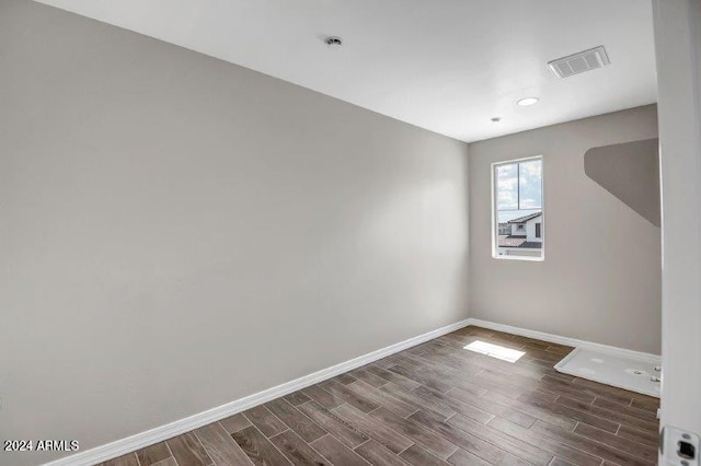 unfurnished room with dark wood-type flooring