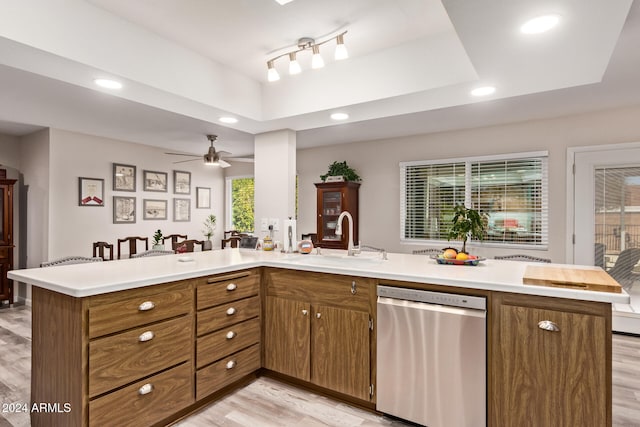 kitchen featuring dishwasher, sink, light hardwood / wood-style flooring, ceiling fan, and kitchen peninsula