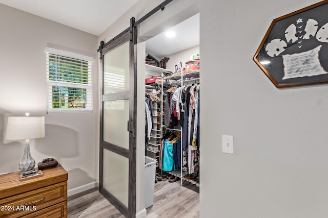 walk in closet with light hardwood / wood-style flooring