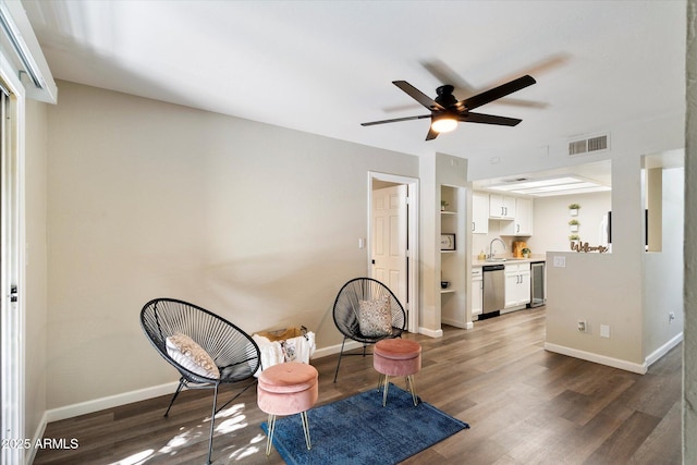 living area with dark hardwood / wood-style flooring, ceiling fan, sink, and built in shelves