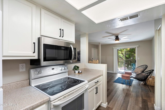 kitchen featuring white cabinets, white electric range oven, and dark hardwood / wood-style floors