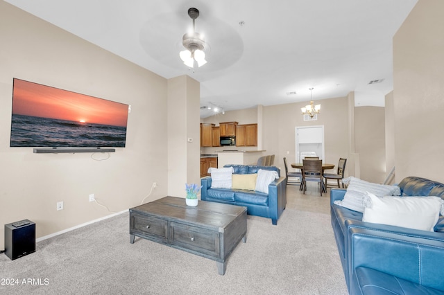 carpeted living room with ceiling fan with notable chandelier