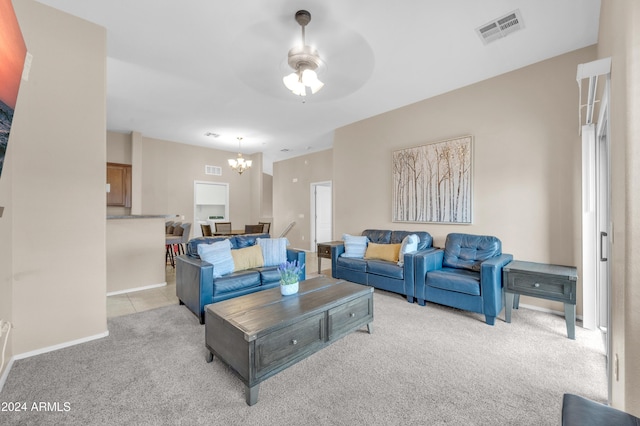 carpeted living room featuring ceiling fan with notable chandelier