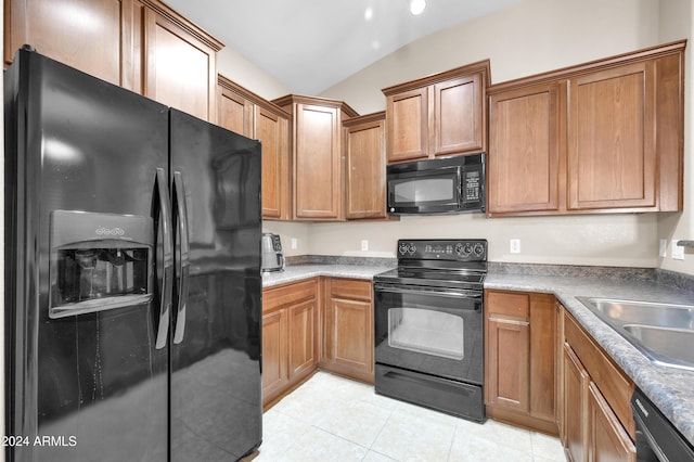 kitchen with sink, light tile patterned floors, black appliances, and lofted ceiling