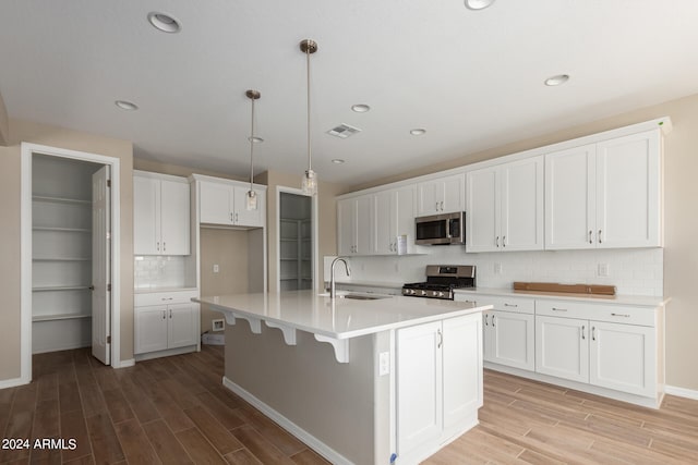 kitchen featuring light hardwood / wood-style flooring, stainless steel appliances, an island with sink, and sink