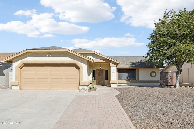 ranch-style home with a garage, fence, concrete driveway, and stucco siding