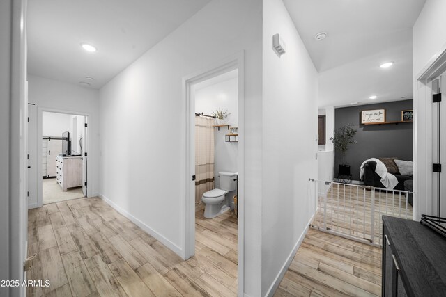 hall featuring recessed lighting, light wood-style flooring, and baseboards
