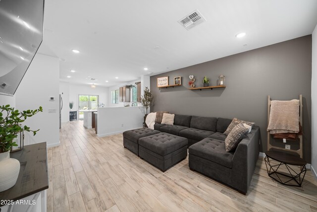 living area featuring visible vents, recessed lighting, light wood-style flooring, and baseboards