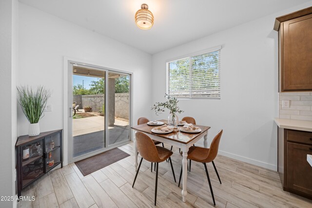 dining space featuring light wood-style floors and baseboards