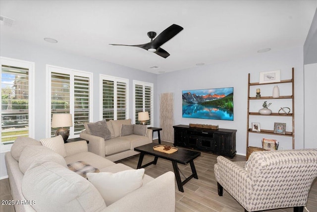 living area with visible vents, light wood-style flooring, and a ceiling fan