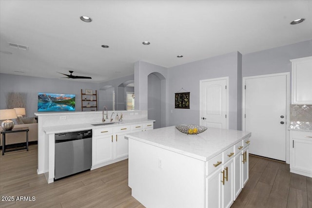 kitchen featuring light wood finished floors, visible vents, open floor plan, stainless steel dishwasher, and a sink