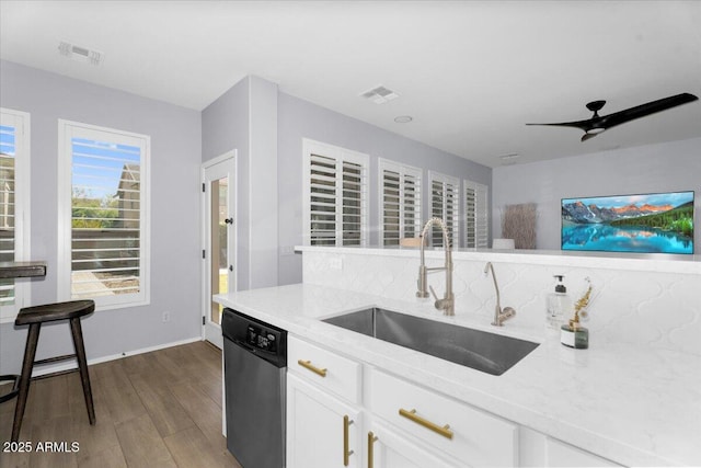 kitchen with a sink, visible vents, dishwasher, and dark wood-style floors