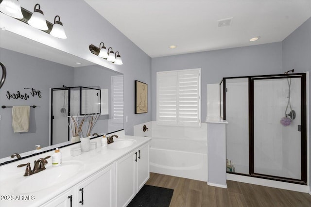 full bath with visible vents, a garden tub, a stall shower, a sink, and wood finished floors