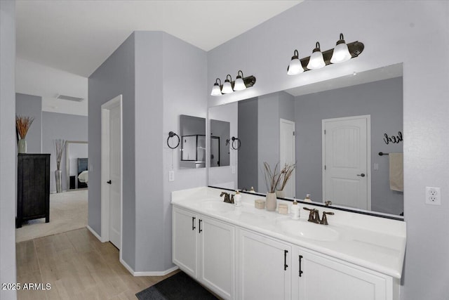 full bathroom featuring double vanity, visible vents, wood finished floors, and a sink