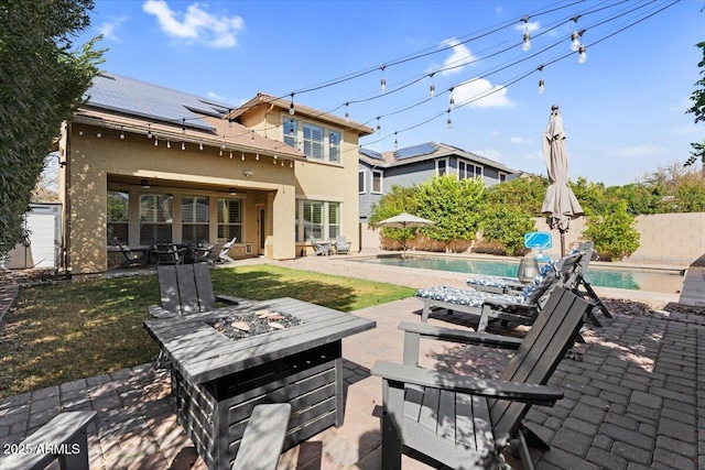 view of patio / terrace with a fenced in pool, a fire pit, and a fenced backyard