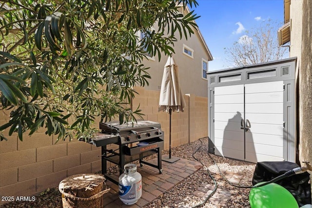 view of patio featuring grilling area, an outbuilding, a shed, and fence