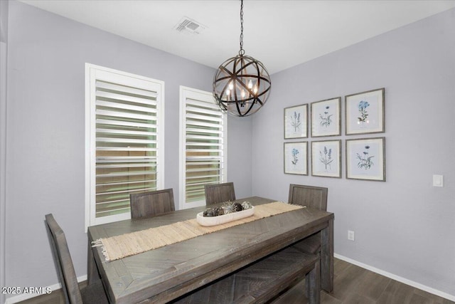 dining area featuring visible vents, a notable chandelier, and dark wood finished floors