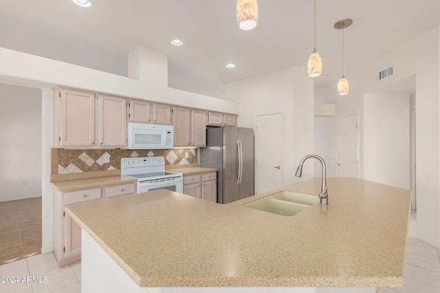 kitchen featuring a kitchen island with sink, sink, white appliances, light tile patterned floors, and decorative light fixtures