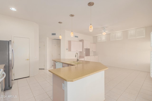 kitchen featuring ceiling fan, white cabinets, an island with sink, pendant lighting, and stainless steel fridge