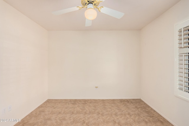 spare room featuring light carpet and ceiling fan