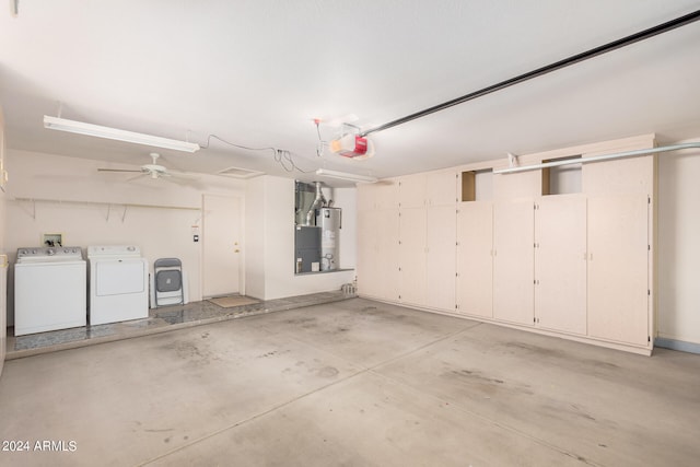 garage featuring water heater, ceiling fan, washer and dryer, and a garage door opener