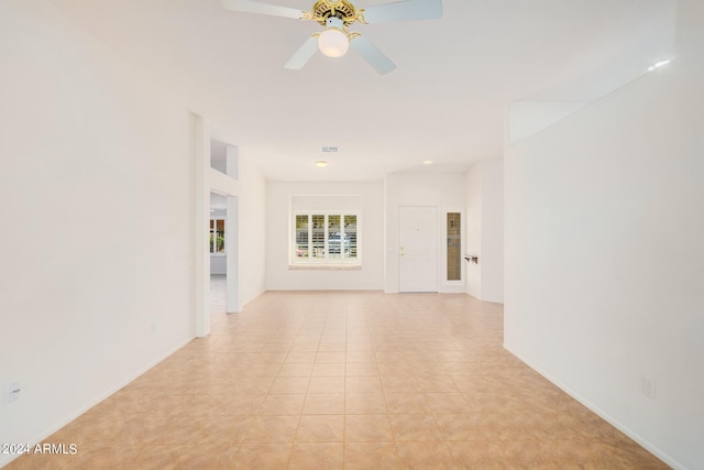 tiled spare room with ceiling fan