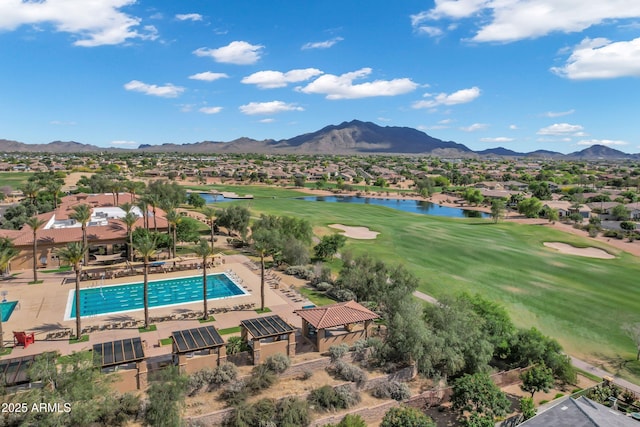 drone / aerial view featuring view of golf course, a residential view, and a water and mountain view