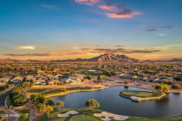 aerial view featuring a water and mountain view, view of golf course, and a residential view