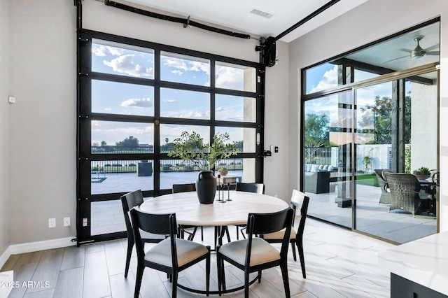 dining area with a water view, baseboards, and visible vents
