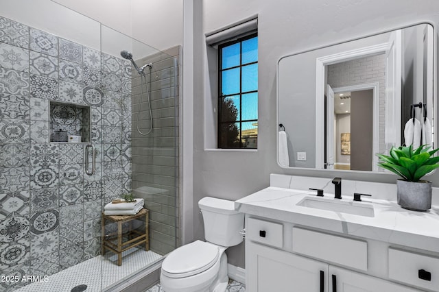 bathroom featuring toilet, a shower stall, and vanity