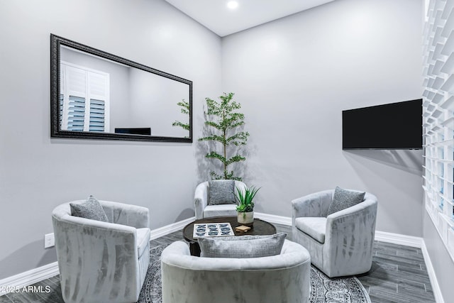 living area featuring baseboards and wood finished floors