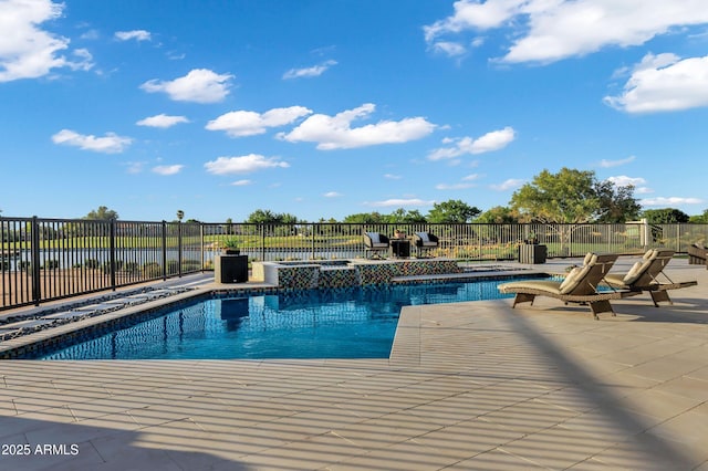 view of pool with fence, a patio, and a pool with connected hot tub