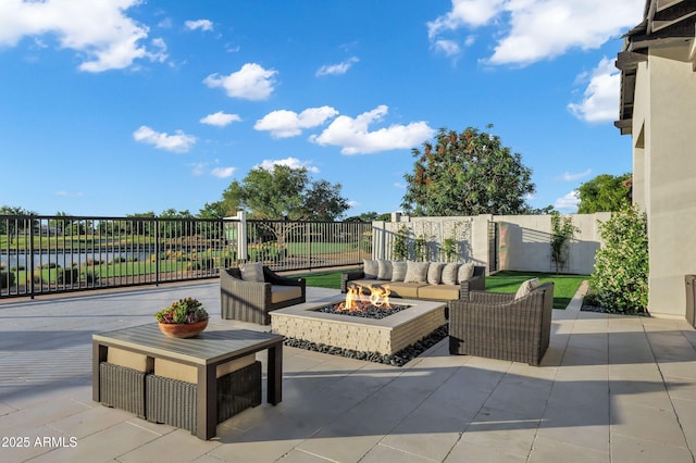 view of patio / terrace featuring fence, an outdoor living space with a fire pit, and a water view