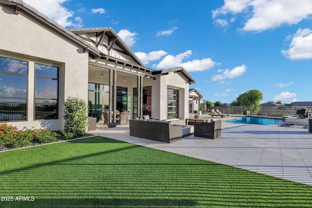 rear view of house featuring a lawn, an outdoor hangout area, a patio area, and stucco siding