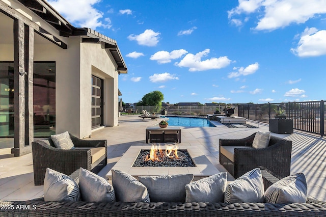 view of patio featuring a fenced in pool and an outdoor living space with a fire pit