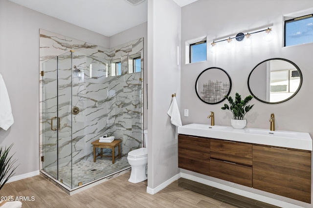 full bathroom with toilet, a sink, a marble finish shower, and wood tiled floor