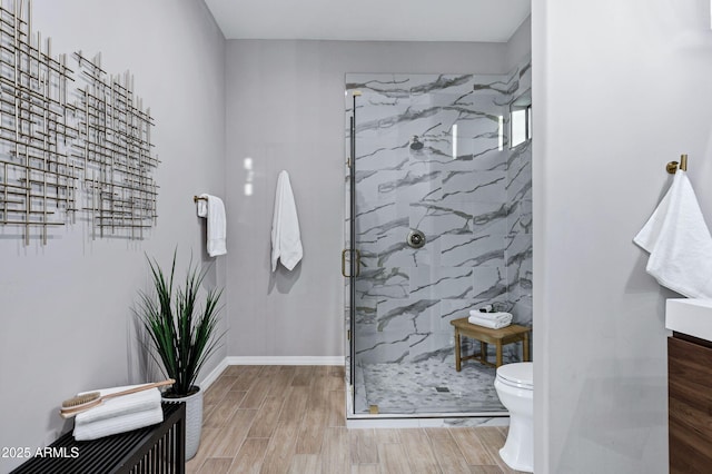 full bathroom with vanity, toilet, a marble finish shower, and wood finished floors