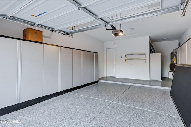 garage featuring a garage door opener and water heater