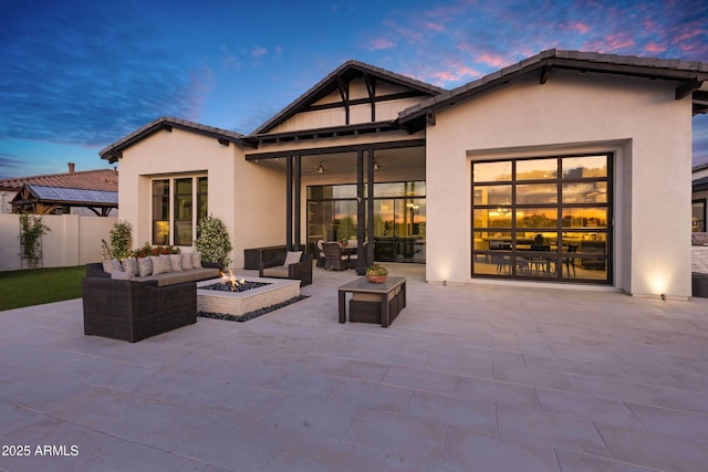 back of property featuring a patio, an outdoor living space with a fire pit, stucco siding, and fence