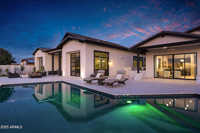 back of house featuring an outdoor hangout area, a patio area, and stucco siding