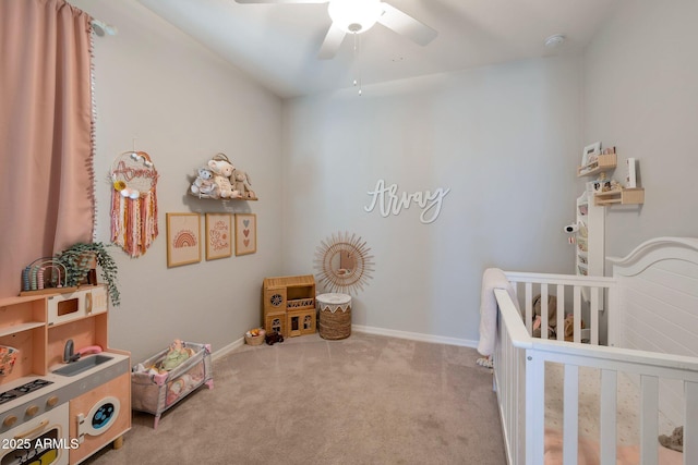 carpeted bedroom featuring ceiling fan and a crib