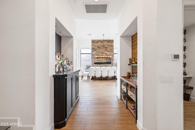 hallway featuring hardwood / wood-style flooring and visible vents