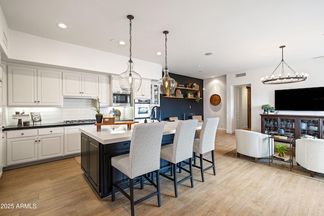 kitchen featuring white cabinets, light wood finished floors, visible vents, and stainless steel appliances