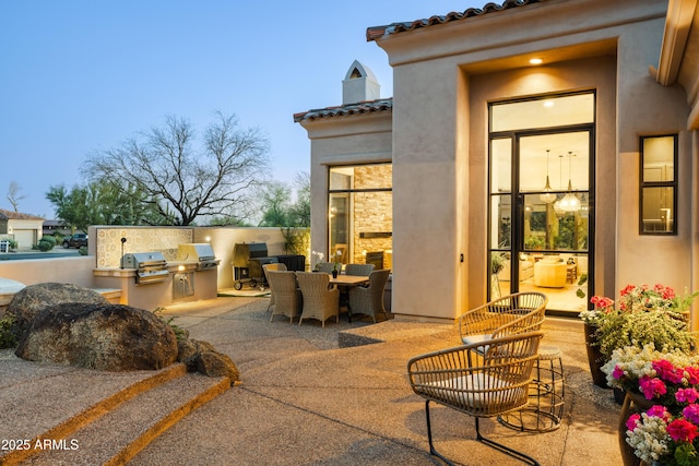 view of patio / terrace featuring a grill, outdoor dining area, and exterior kitchen