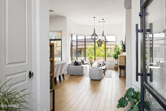 interior space featuring an inviting chandelier, visible vents, and light wood-style floors