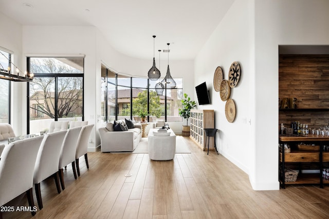 living area with a wealth of natural light, a fireplace, light wood-style flooring, and baseboards