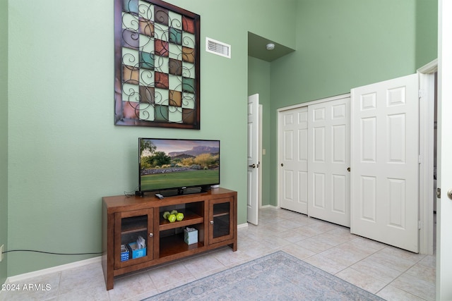 interior space with light tile patterned flooring and a high ceiling