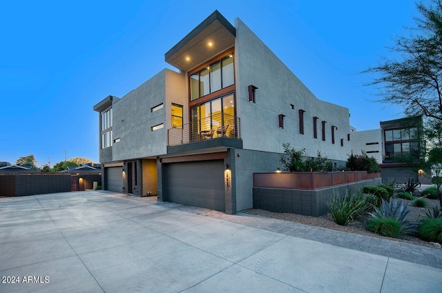 view of front of home with concrete driveway, a garage, and stucco siding